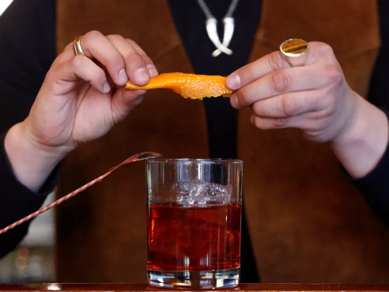 What role does a garnish play in a cocktail, and which should a bar stock?