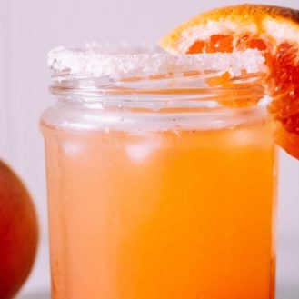 Tangy Love Hibiscus Orange Mocktail with muddled lime leaf